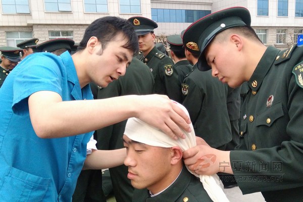 男护士教战士如何包扎头部伤口.
