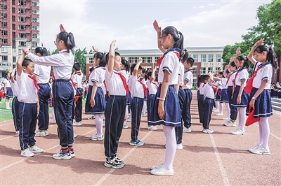 5月31日，高年级的少先队员为一年级的新队员戴上鲜艳的红领巾。为让孩子们度过一个有意义的“六一”儿童节，银川市兴庆区二十七小学举行少先队入队仪式。本报记者  韩胜利  摄